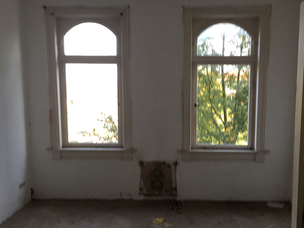 Wohnräume mit Stichbogenfenstern vor der Sanierung